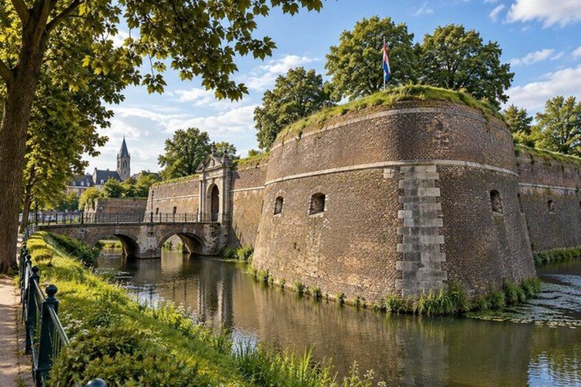 A historic stone fortification with a bridge, a river, and a flag on top. 5