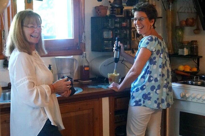 Two people in a kitchen, one holding a food processor. 1
