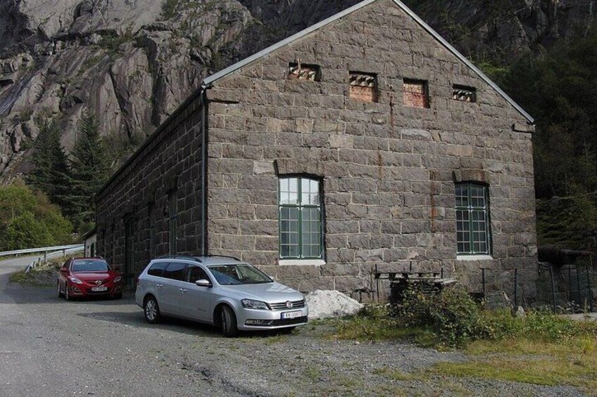 A stone building with a car parked in front. 2