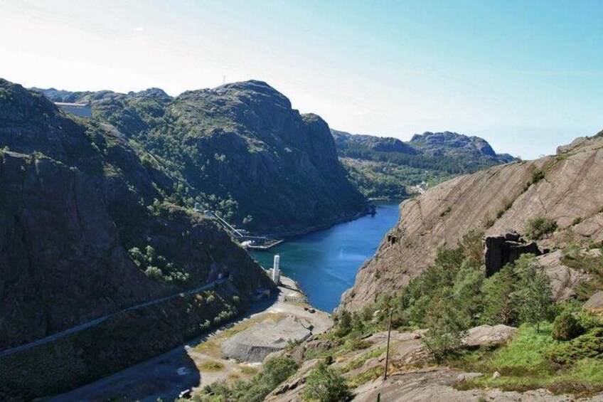 A canyon with a river, rocky cliffs, and a bridge. 5