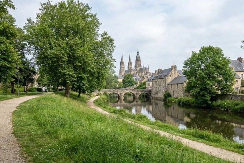 A river with a bridge, a pathway, and a historic building in the background. 4