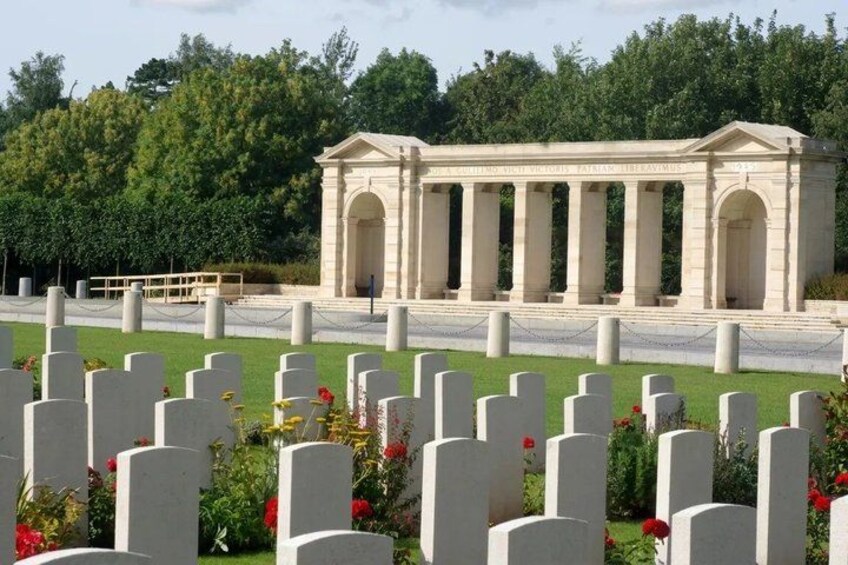 A cemetery with white headstones and a neoclassical monument. 2