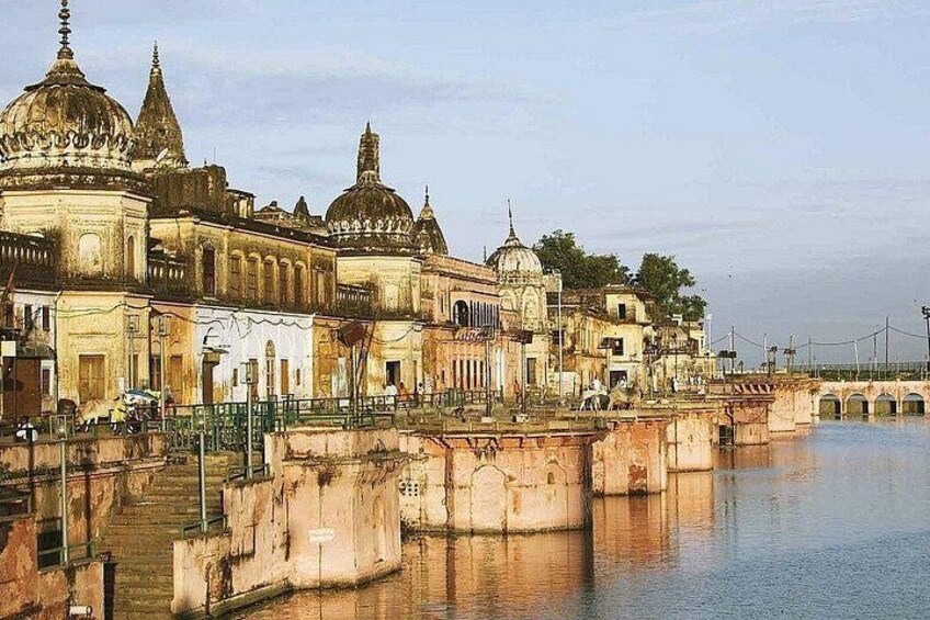 A historic building with domes, a bridge, and a calm river. 5