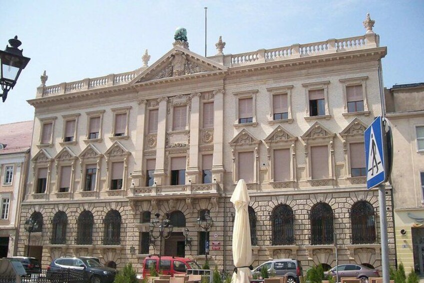 A historic building with ornate architecture, including arched windows and a balcony. 5