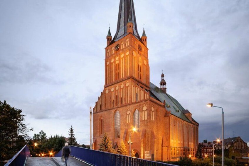 A large, illuminated church with a tall spire and a clock tower. 3