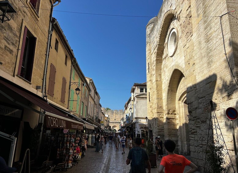 Une rue étroite bordée de boutiques et un bâtiment historique en pierre, doté d’une arche. 4