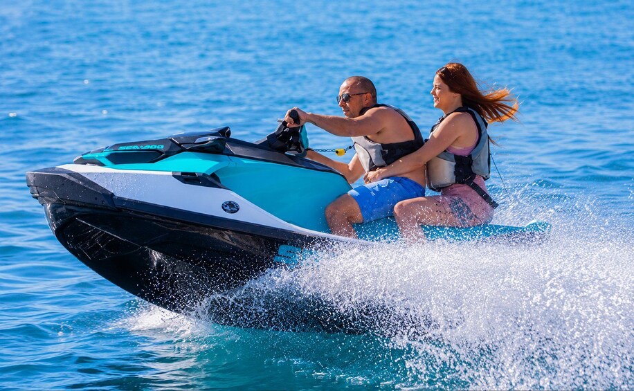 Zwei Personen fahren mit einem Jetski über das Wasser. 2