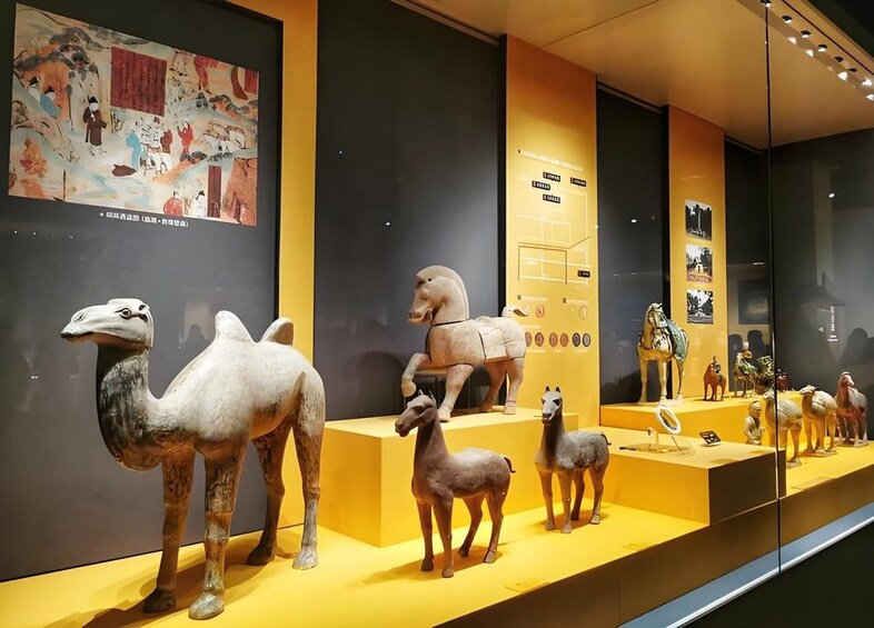 Une exposition de musée présentant des sculptures de chameaux et de chevaux. 3