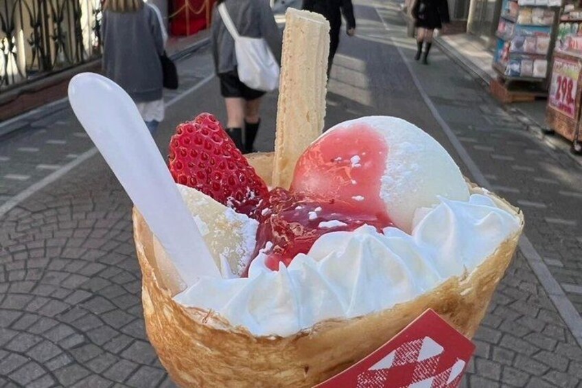 A dessert with ice cream, strawberries, and whipped cream in a basket. 2
