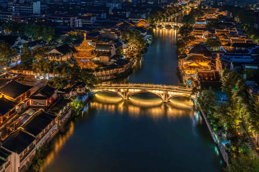 Une rivière bordée d’édifices à l’architecture traditionnelle et traversée par un pont. 5