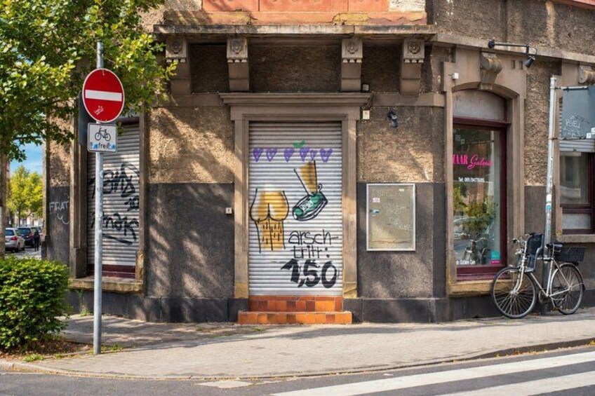 A building with a closed shutter, a no entry sign, and a bicycle parked outside. 4