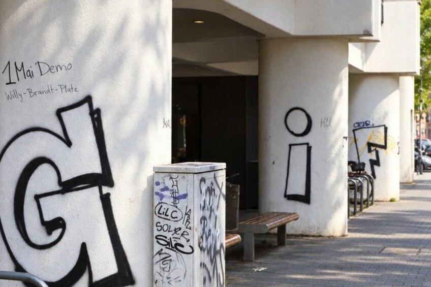 A building with graffiti, a bench, and a bicycle rack. 5