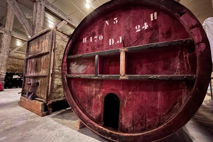 A large, round, red barrel with inscriptions and a small opening. 5