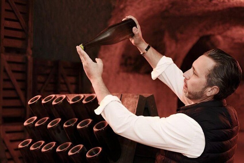 A person pouring a liquid from a bottle into a glass. 1