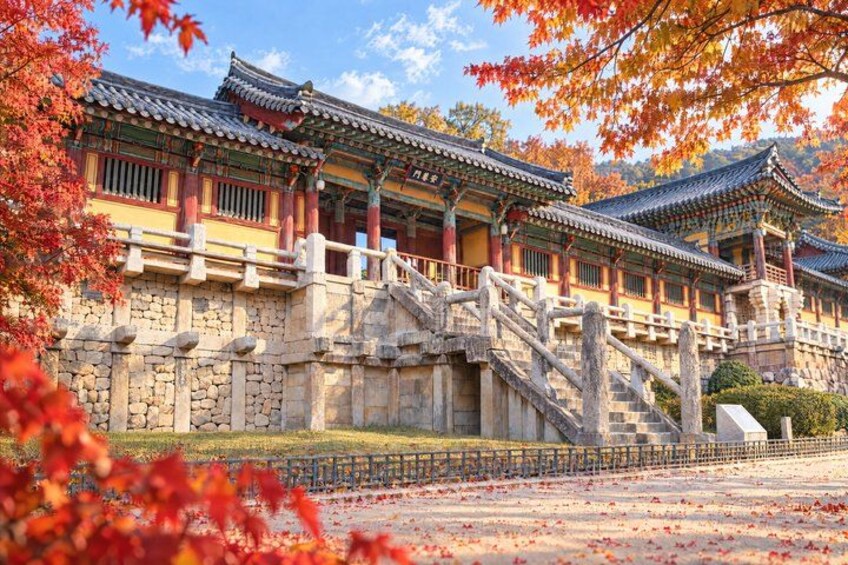 A traditional Korean palace with ornate architecture, a stone bridge, and autumn foliage. 3