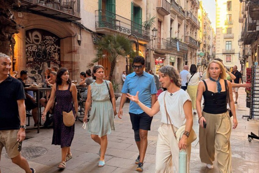 A busy urban street with pedestrians, buildings, and outdoor seating areas. 1