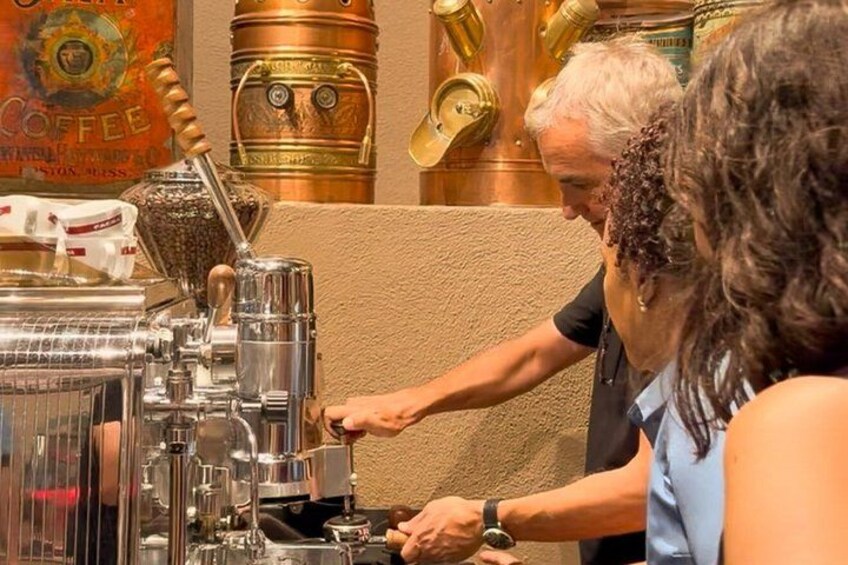 A person operating a coffee machine in a cafe. 2