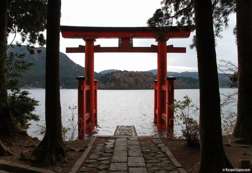 A red torii gate leading to a lake surrounded by trees and hills. 3