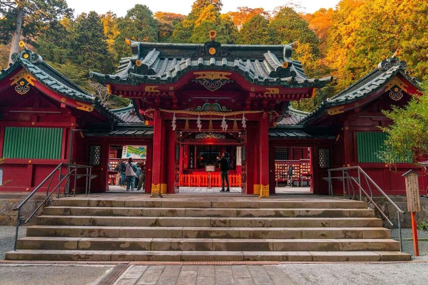 A traditional Chinese temple with red and green architecture, surrounded by autumn trees. 5