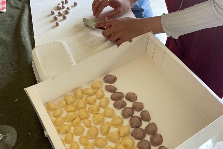 A person opening a box of round pastries, some of which are yellow and others brown. 3