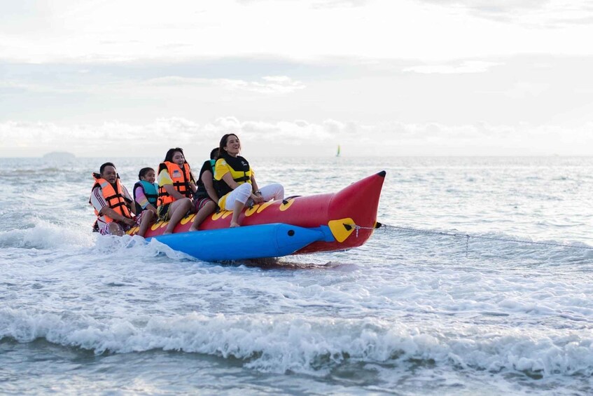 A group of people on a red and blue inflatable raft in the ocean. 1