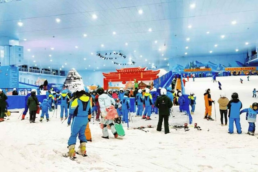 An indoor skiing facility with artificial snow, ski equipment, and people skiing. 3
