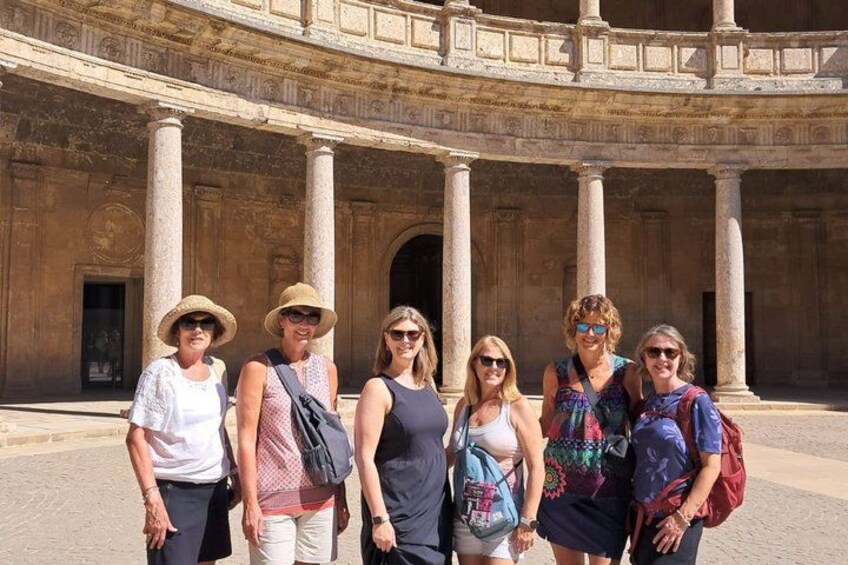 A group of people standing in front of an ancient amphitheater with columns. 5