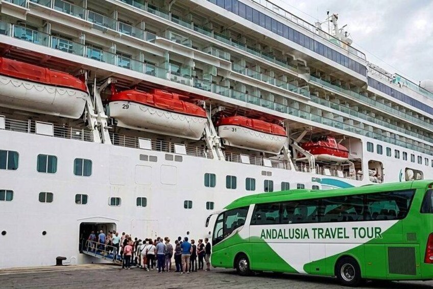 A cruise ship with lifeboats and a green bus labeled 'ANDALUSIA TRAVEL TOUR' parked in front. 1