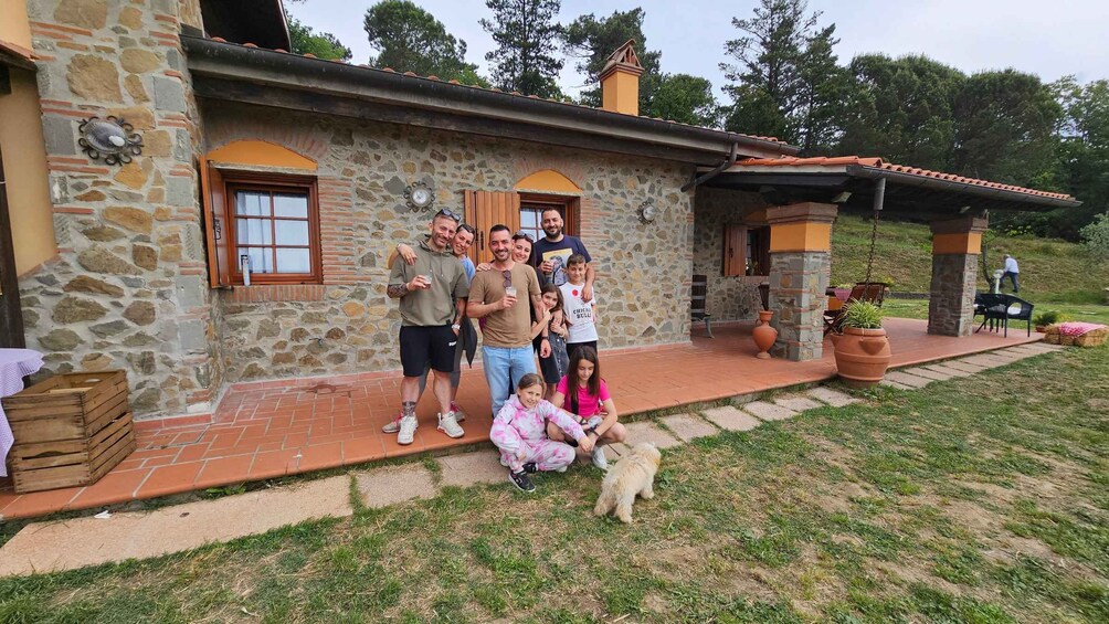 Une maison en pierre avec un toit en tuiles, un chemin en briques et une pelouse où se trouve un chien. 3