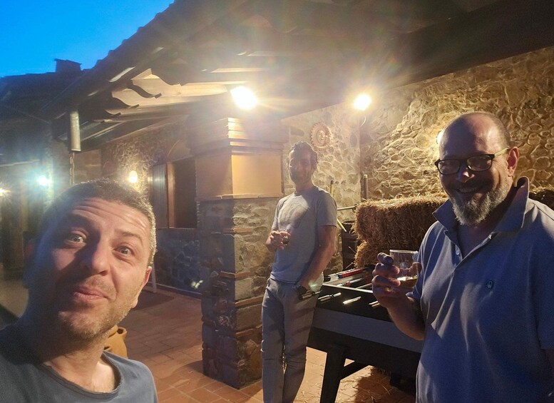 Un groupe de personnes se trouve à l’extérieur, de nuit, près d’un bâtiment en pierre dont l’intérieur est de style rustique. 5