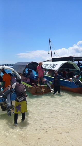 A group of people on boats near a dock, with a clear sky and calm water. 3