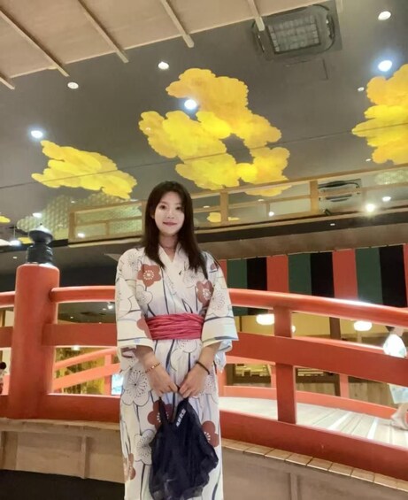 A person in a traditional kimono standing on a bridge with a railing. 5