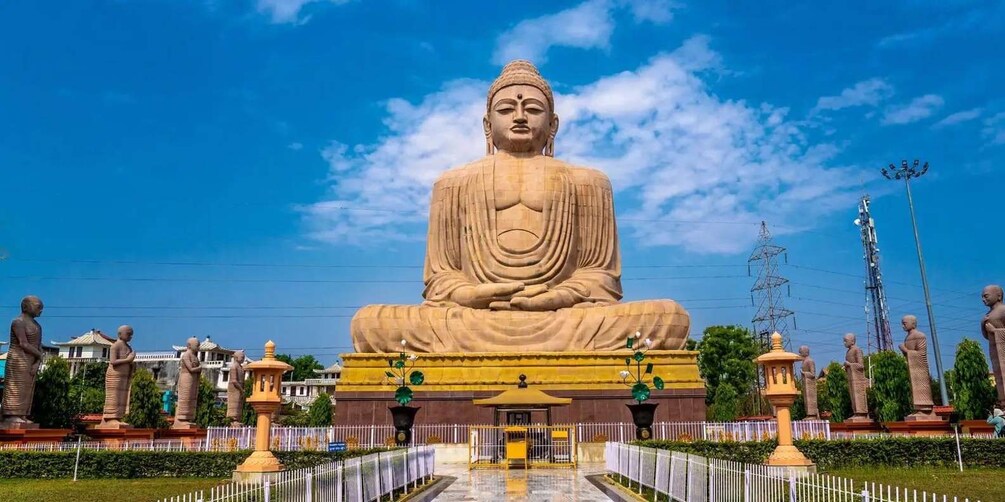Une grande statue de Bouddha assis, entourée de statues plus petites et d’éléments d’architecture traditionnelle. 4