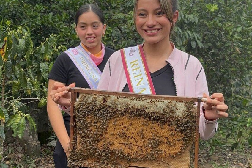 Two individuals holding a beehive. 4