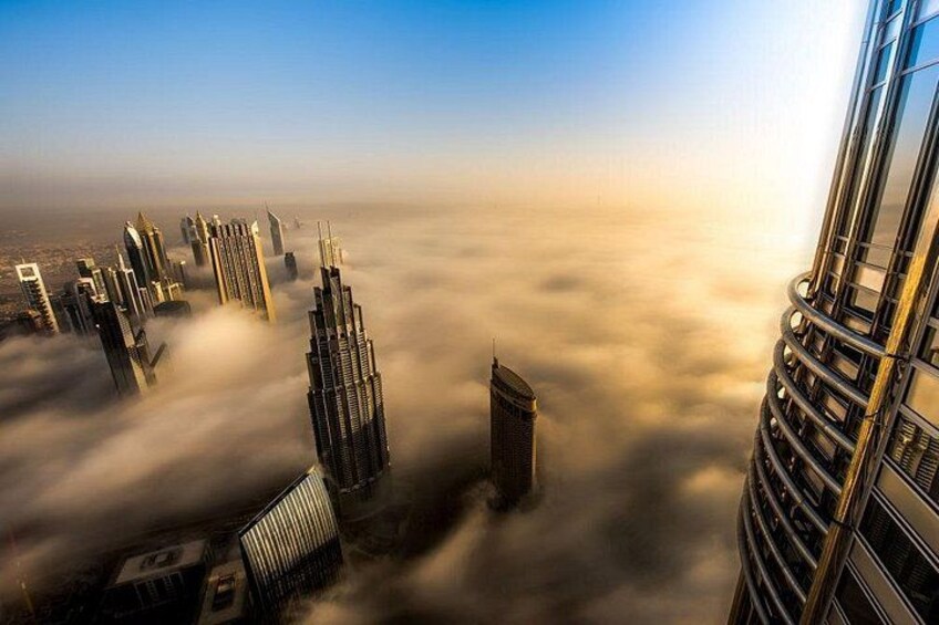 A cityscape with skyscrapers and clouds below. 2