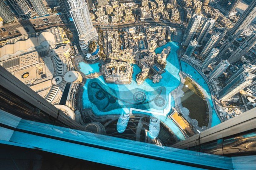 A high-angle view of a cityscape with prominent skyscrapers, a large body of water, and a distinctive architectural structure with a circular design. 5