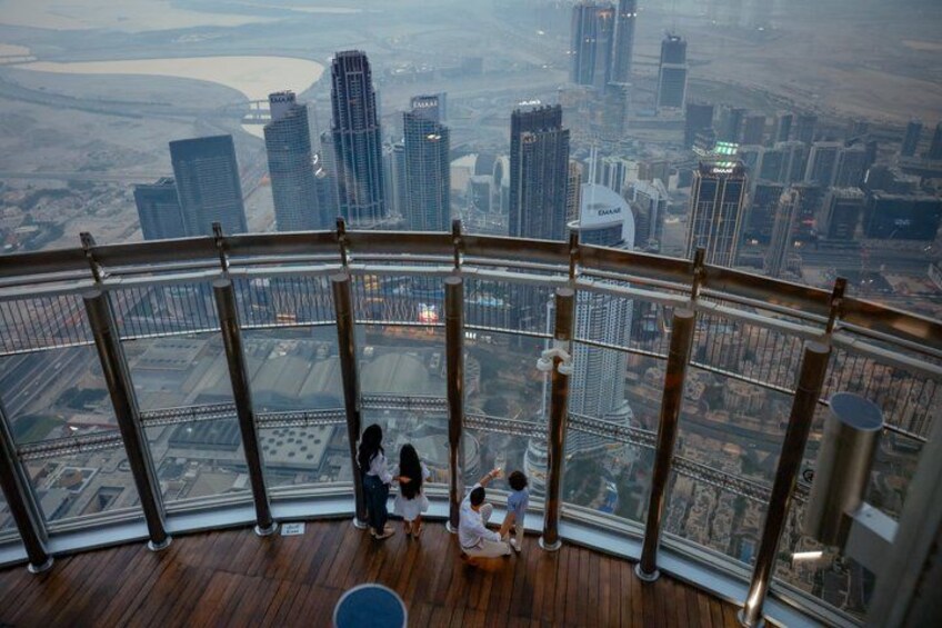 A high-rise observation deck with a panoramic view of a cityscape, including skyscrapers and a river. 4