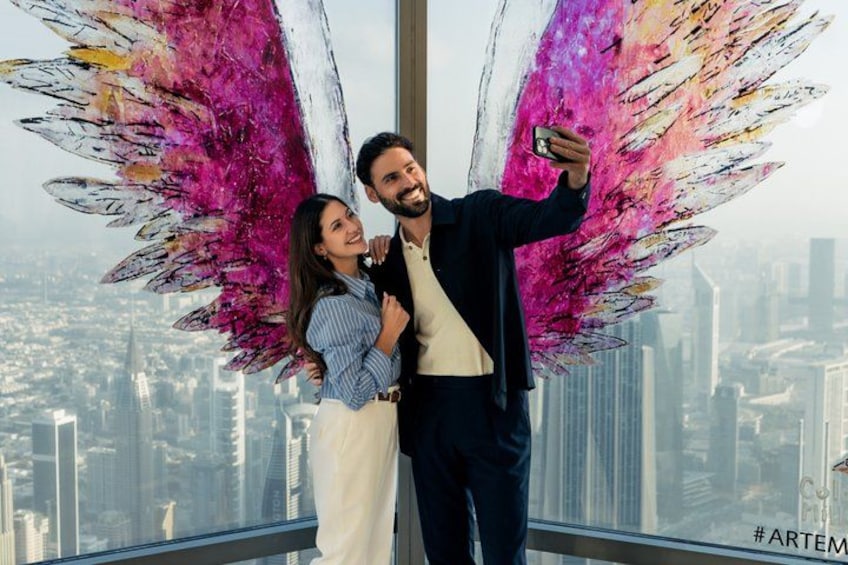 A person taking a selfie with a cityscape in the background. 3