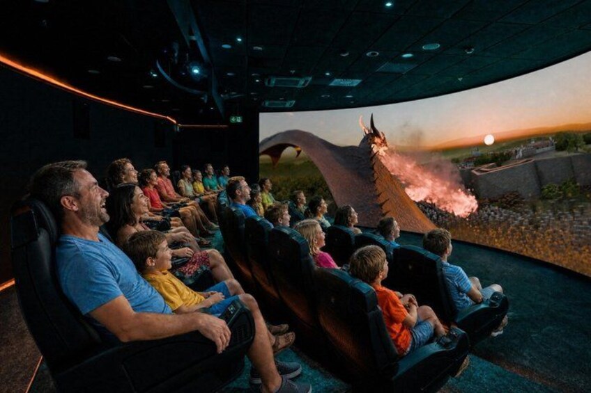 An indoor roller coaster with passengers seated in rows. 1