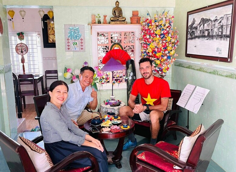 A room with a Buddha statue, a calendar, a painting, and a table with food and drinks. 4