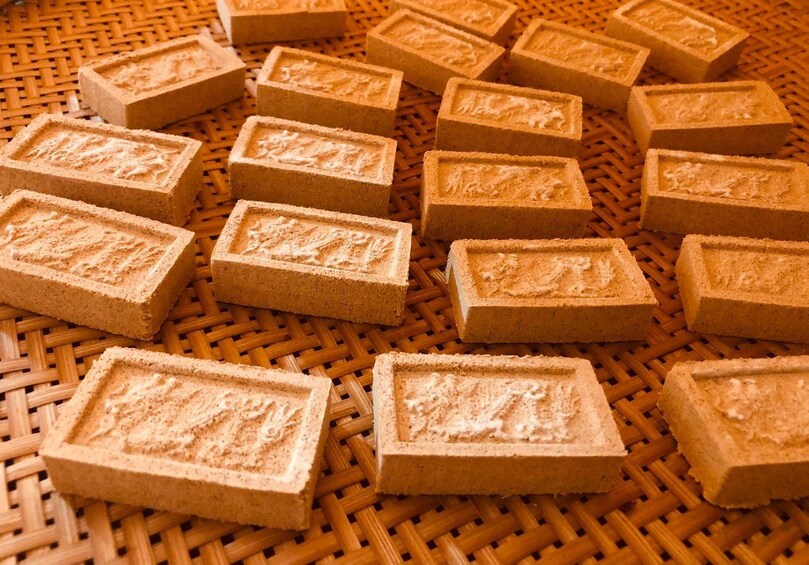 Rectangular blocks of food arranged on a woven surface. 3