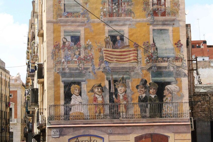 Une fresque ornant un bâtiment doté de balcons, représentant des personnages historiques et un drapeau. 3
