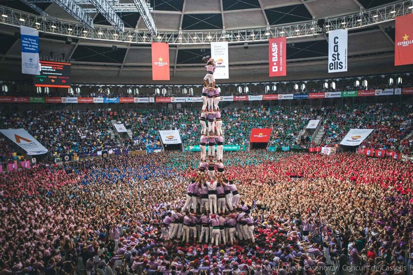 Une foule nombreuse s’est rassemblée autour d’une structure en forme de pyramide dans un stade. 4