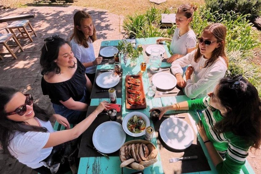 A group of people sitting around a table with food and drinks. 1