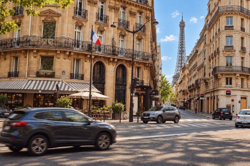 A Parisian street with cars, a café, and the Eiffel Tower in the background. 3