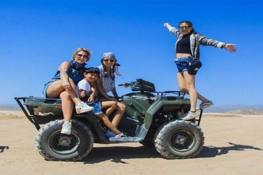 A group of people on a quad bike in a desert landscape. 2