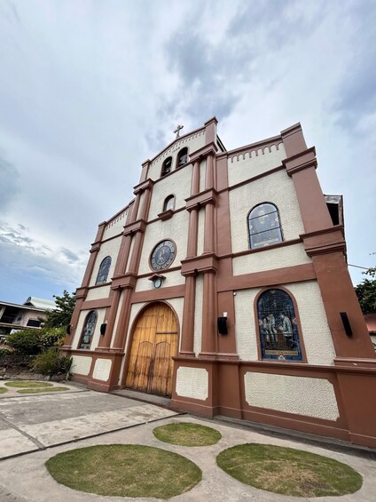 Eine historische Kirche mit einer großen Holztür und Rundbogenfenstern. 1