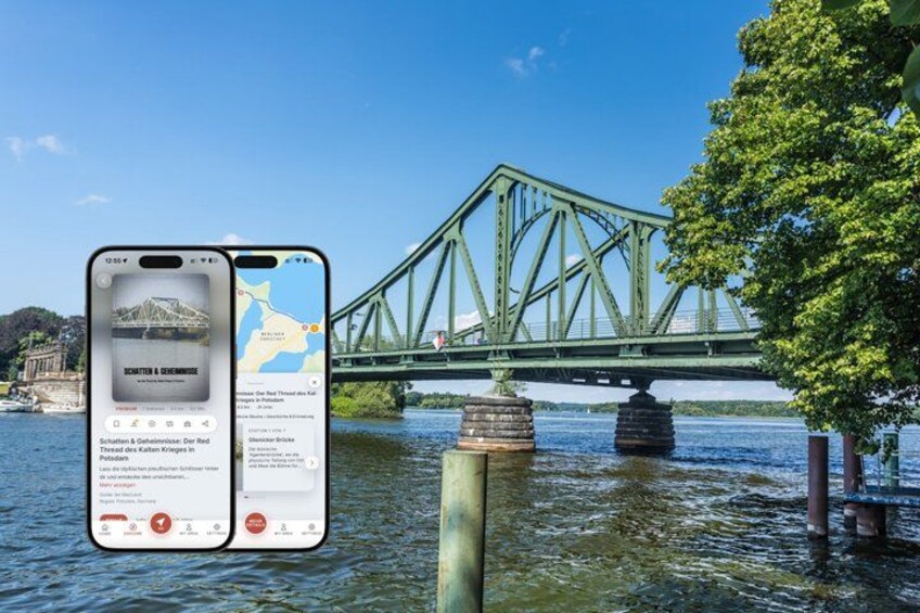 A green bridge over water, a smartphone displaying a map, and a tree. 1