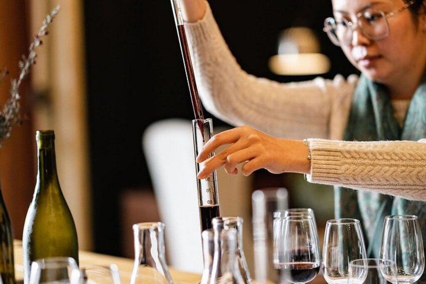A person pouring a liquid from a bottle into a glass. 2
