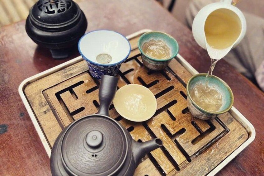 A traditional tea set with a teapot, cups, and a tray. 5